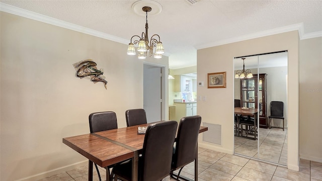 tiled dining room featuring a chandelier, a textured ceiling, and ornamental molding