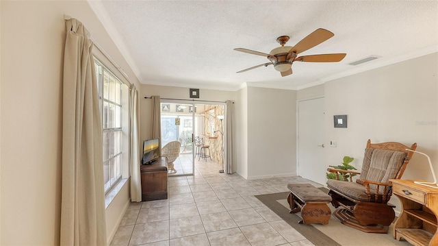 sitting room with ceiling fan, ornamental molding, a textured ceiling, and light tile patterned floors