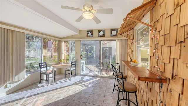 sunroom / solarium featuring ceiling fan and beam ceiling