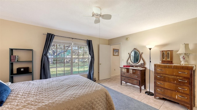 tiled bedroom with ceiling fan and a textured ceiling