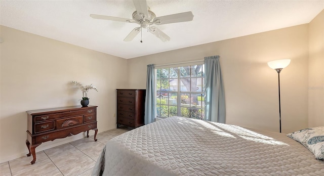 bedroom featuring ceiling fan, light tile patterned flooring, and a textured ceiling