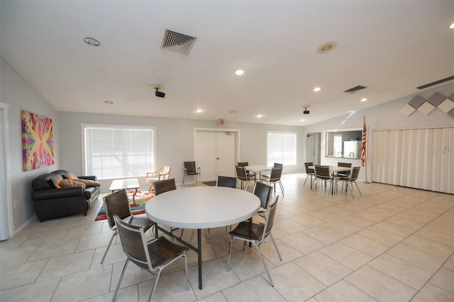 dining space with lofted ceiling and light tile patterned flooring