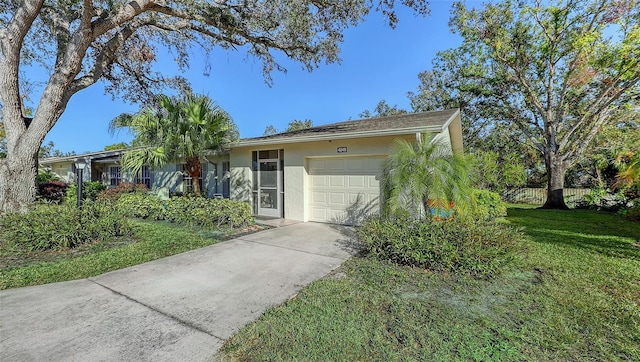 ranch-style house featuring a garage and a front lawn