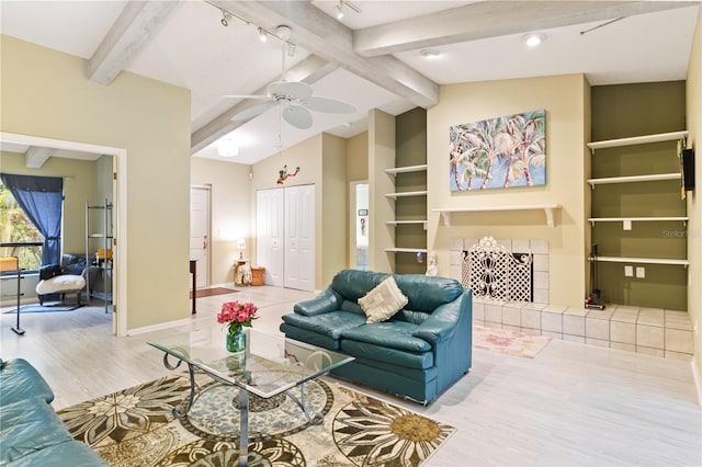 living room featuring lofted ceiling with beams, light hardwood / wood-style floors, rail lighting, and ceiling fan