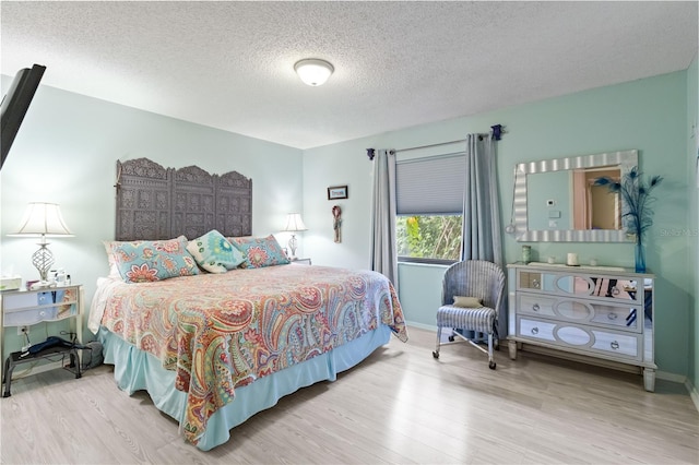 bedroom with hardwood / wood-style flooring and a textured ceiling