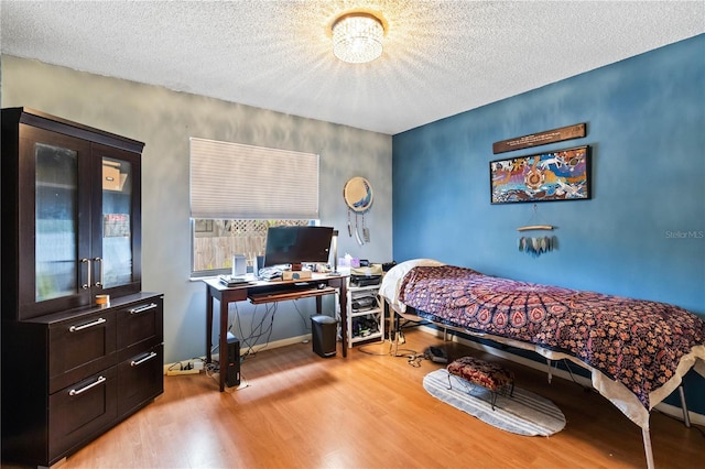 bedroom featuring hardwood / wood-style floors and a textured ceiling