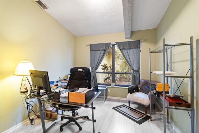 home office with hardwood / wood-style floors, lofted ceiling with beams, and a textured ceiling