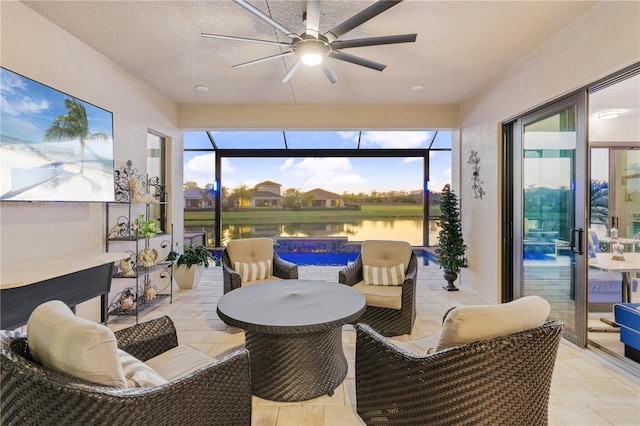 sunroom with a water view and ceiling fan