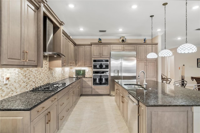 kitchen featuring sink, dark stone countertops, appliances with stainless steel finishes, pendant lighting, and a kitchen island with sink