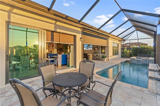 view of swimming pool with an in ground hot tub, glass enclosure, and a patio area