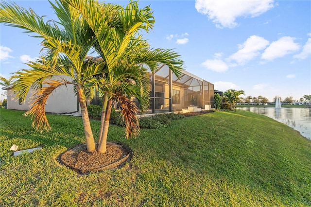 view of yard with a water view and a lanai