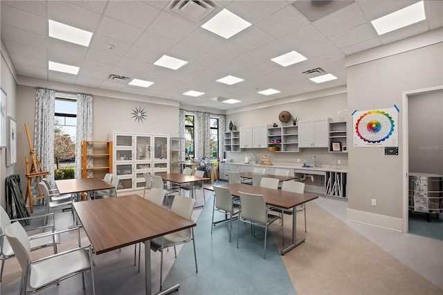 dining area featuring sink and a drop ceiling