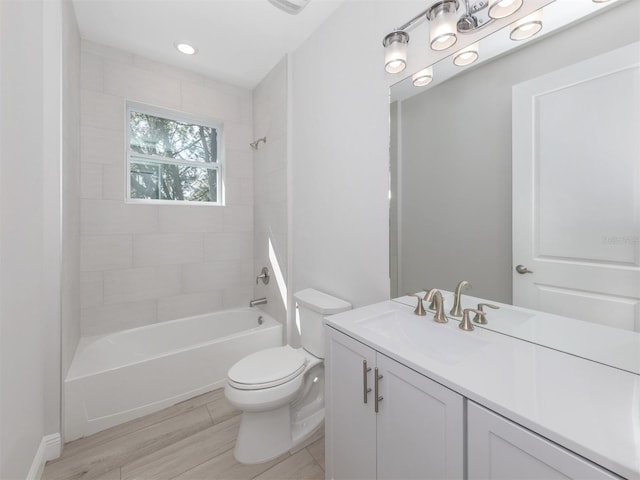 full bathroom with vanity, toilet, tiled shower / bath, and hardwood / wood-style flooring