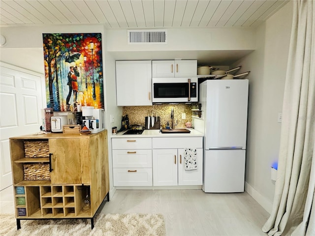 kitchen featuring white cabinets, decorative backsplash, white appliances, and sink