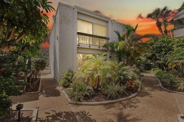 property exterior at dusk featuring a balcony