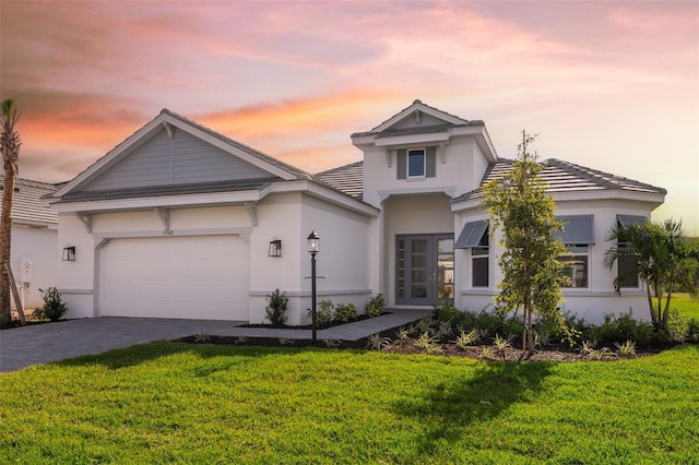 view of front of property featuring a lawn and a garage