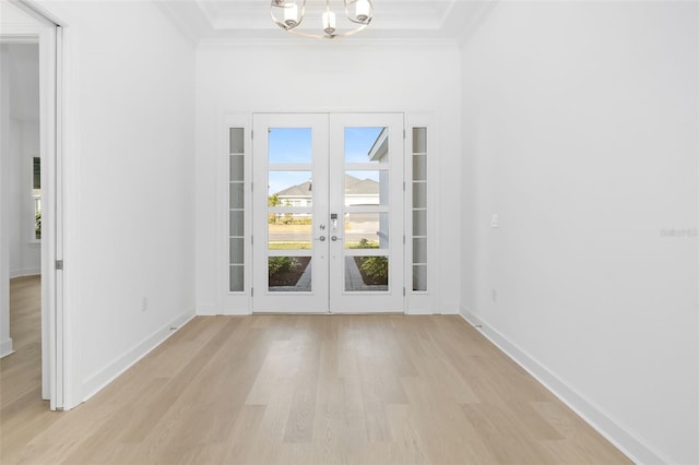 interior space with french doors, an inviting chandelier, light hardwood / wood-style flooring, and crown molding