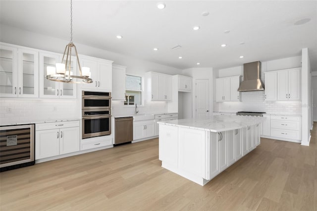 kitchen featuring wine cooler, white cabinetry, and wall chimney exhaust hood