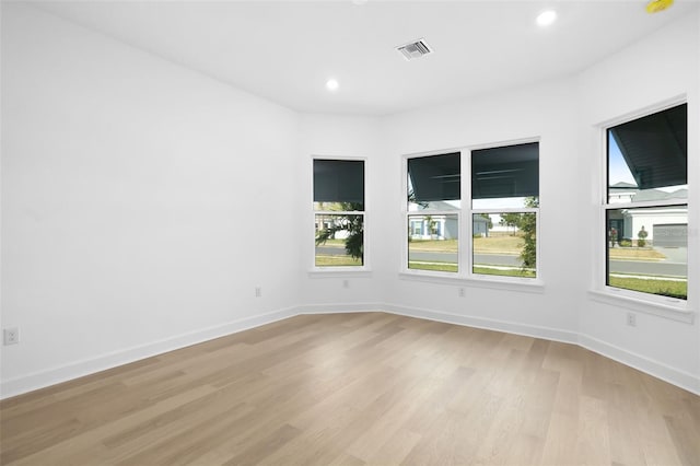 spare room featuring light hardwood / wood-style floors and plenty of natural light