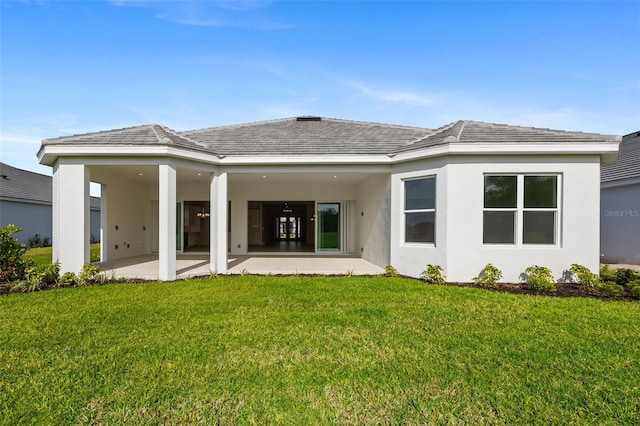 rear view of house with a yard and a patio