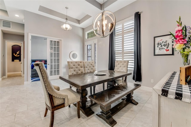 dining space featuring a chandelier, light tile patterned floors, a tray ceiling, and french doors