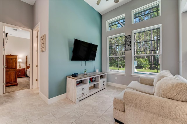 tiled living room with a high ceiling and ceiling fan