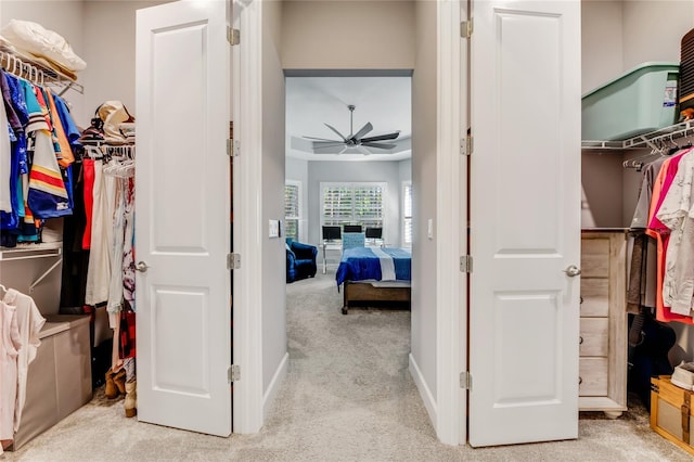 spacious closet featuring light carpet and ceiling fan