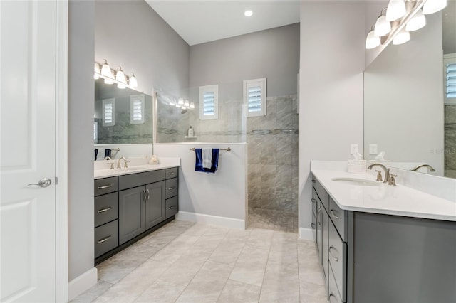 bathroom with a tile shower, tile patterned flooring, and vanity