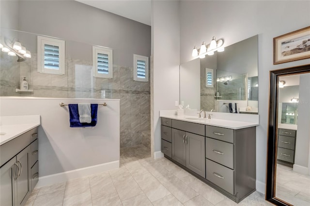 bathroom featuring tile patterned flooring, vanity, and tiled shower