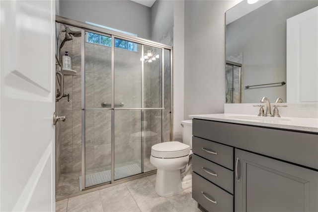 bathroom featuring toilet, vanity, tile patterned floors, and an enclosed shower