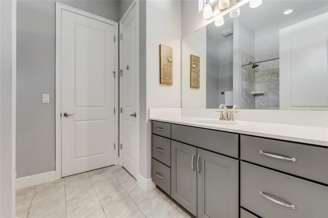 bathroom with tiled shower, vanity, and tile patterned floors