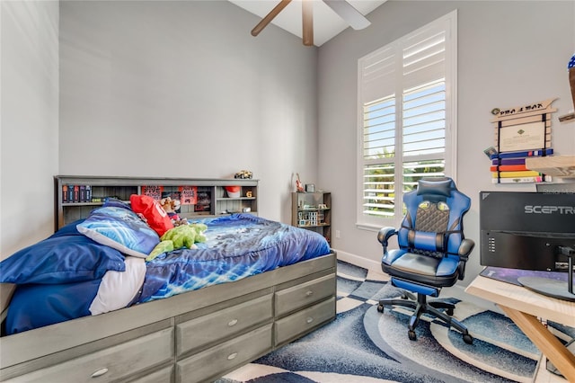 carpeted bedroom featuring beam ceiling and ceiling fan