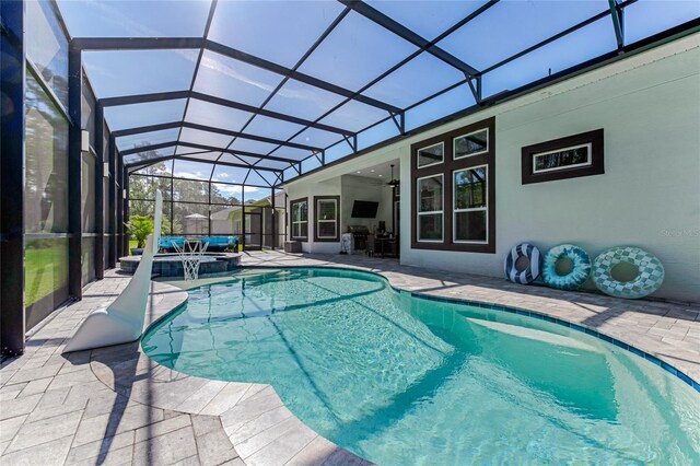 view of swimming pool featuring ceiling fan, a lanai, an in ground hot tub, and a patio