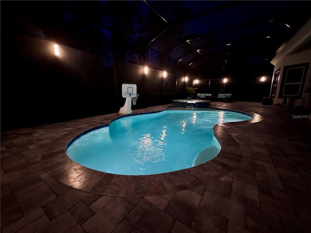 pool at twilight featuring an in ground hot tub and a patio