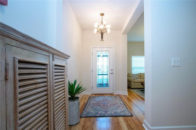 entryway featuring wood-type flooring and a chandelier