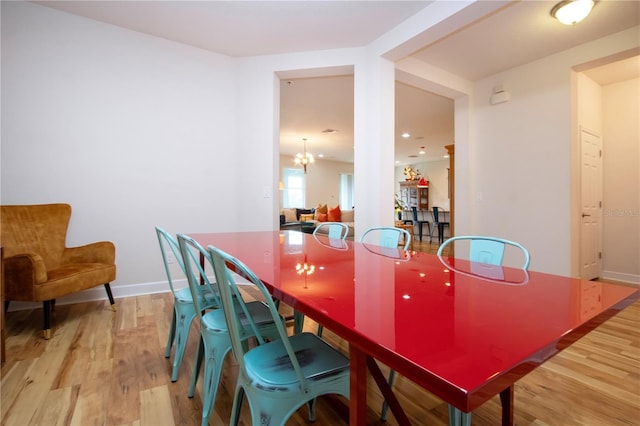 dining area featuring an inviting chandelier and light hardwood / wood-style flooring