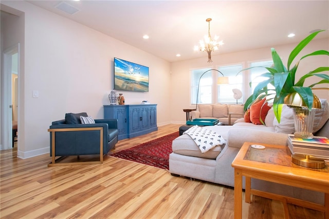 living room with a chandelier and light hardwood / wood-style floors