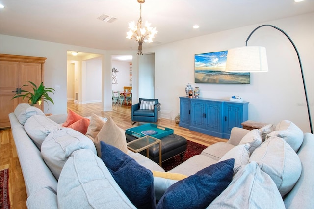 living room with a chandelier and light hardwood / wood-style flooring