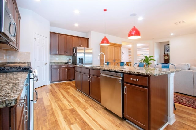 kitchen featuring stainless steel appliances, tasteful backsplash, light hardwood / wood-style floors, and sink