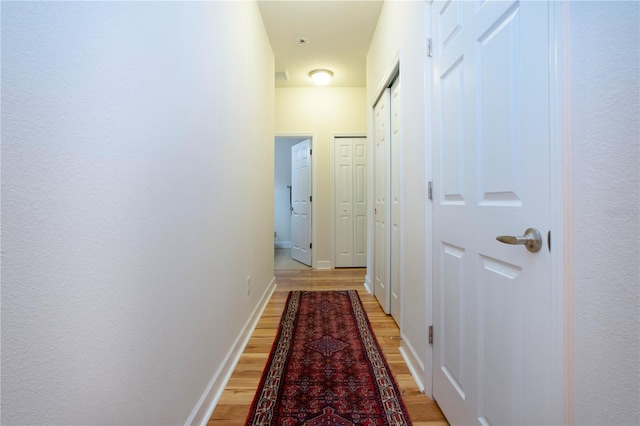 hallway with light hardwood / wood-style floors