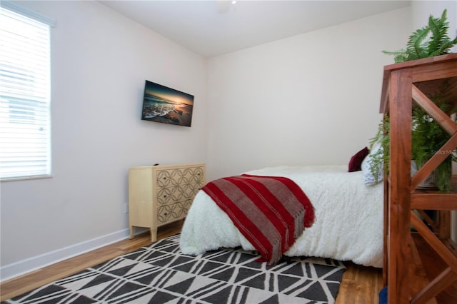 bedroom featuring hardwood / wood-style flooring and multiple windows