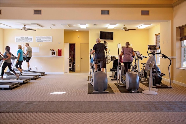 gym featuring carpet, ceiling fan, and crown molding