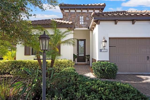 13126 Indigo Way, Bradenton, FL 34211 - mediterranean / spanish-style house with a garage, a tile roof, stucco siding, and stone siding