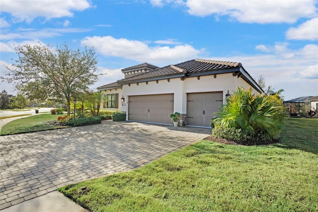 13126 Indigo Way, Bradenton, FL 34211 - view of side of home featuring decorative driveway, a garage, a tile roof, and a lawn