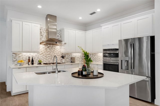13126 Indigo Way, Bradenton, FL 34211 - kitchen with stainless steel appliances, wall chimney range hood, light wood-style floors, a kitchen island with sink, and crown molding