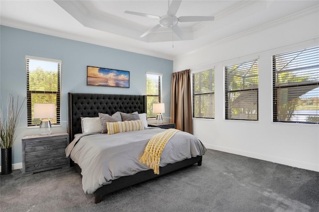 carpeted bedroom featuring ceiling fan, a raised ceiling, crown molding, and multiple windows