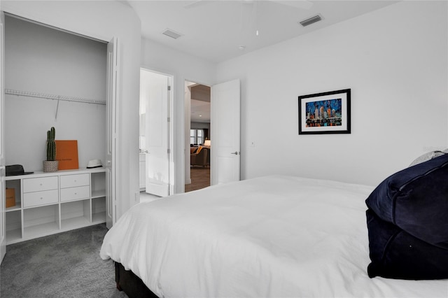 bedroom with ceiling fan, dark carpet, and a closet