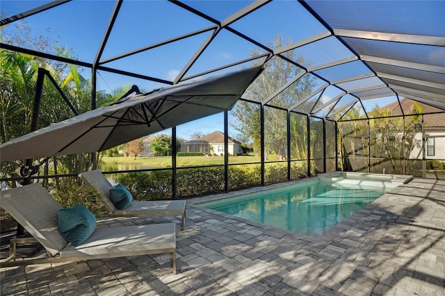 view of pool with glass enclosure and a patio area