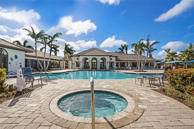 view of swimming pool featuring a community hot tub and a patio