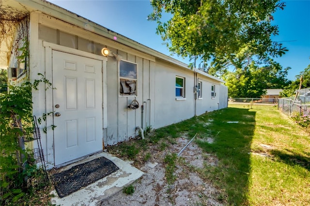 property entrance with a lawn